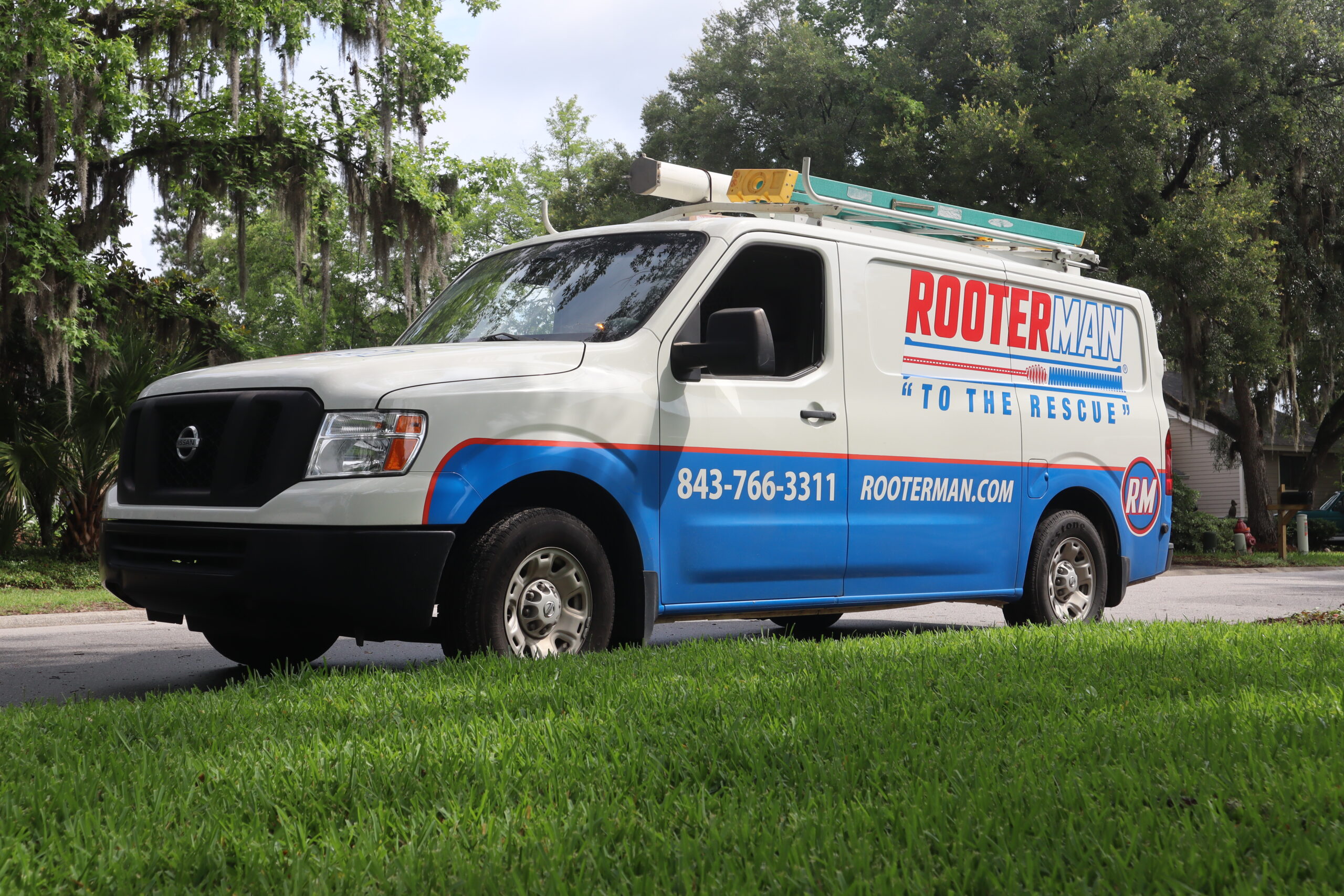 A Rooter Man Plumbing service van parked in Charleston, SC neighborhood.