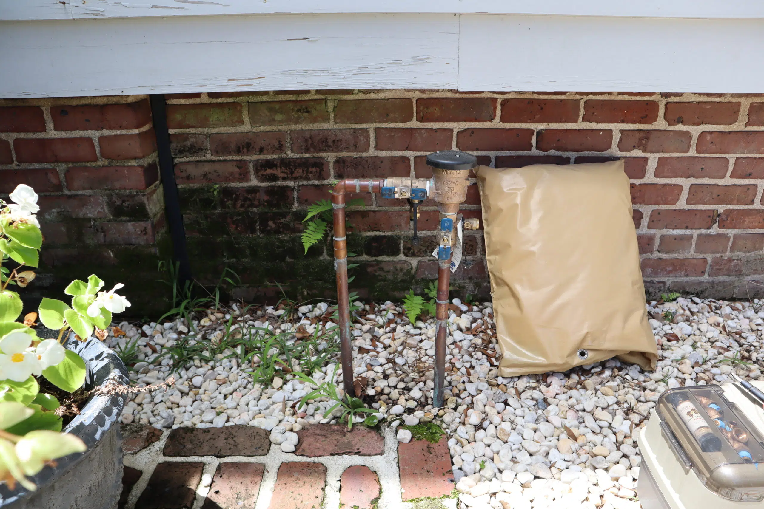 Outdoor backflow preventer setup at a Charleston home, showing irrigation system test and plumbing inspection site.
