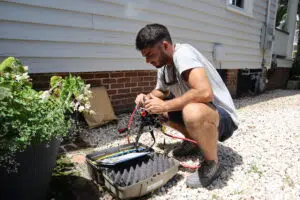 Rooter Man Charleston plumber performing certified backflow testing outside a historic Charleston home.