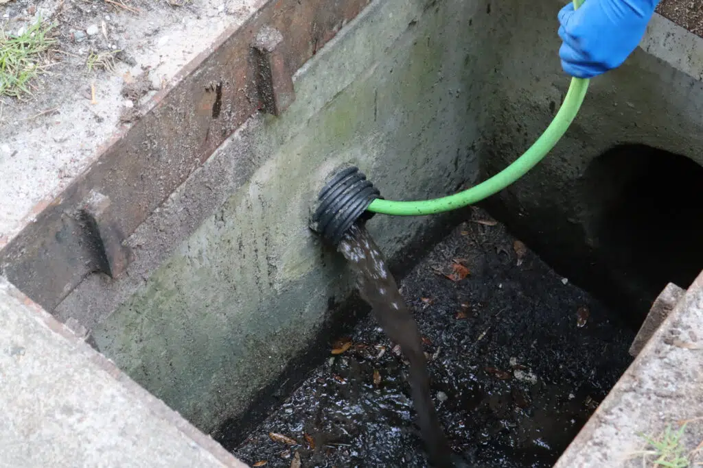 Before storm drain jetting showing clogged drainage line with dirty water in Mount Pleasant SC
