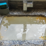 a kitchen sink filled with dirty backed up water.