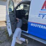 Ashley Cannon with Fuel Express installing a GPS tracker on Rooter Man Plumbing's newly wrapped Charleston service van