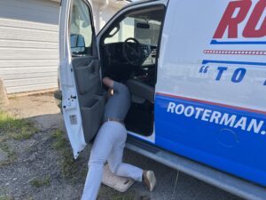 Ashley Cannon with Fuel Express installing a GPS tracker on Rooter Man Plumbing's newly wrapped Charleston service van