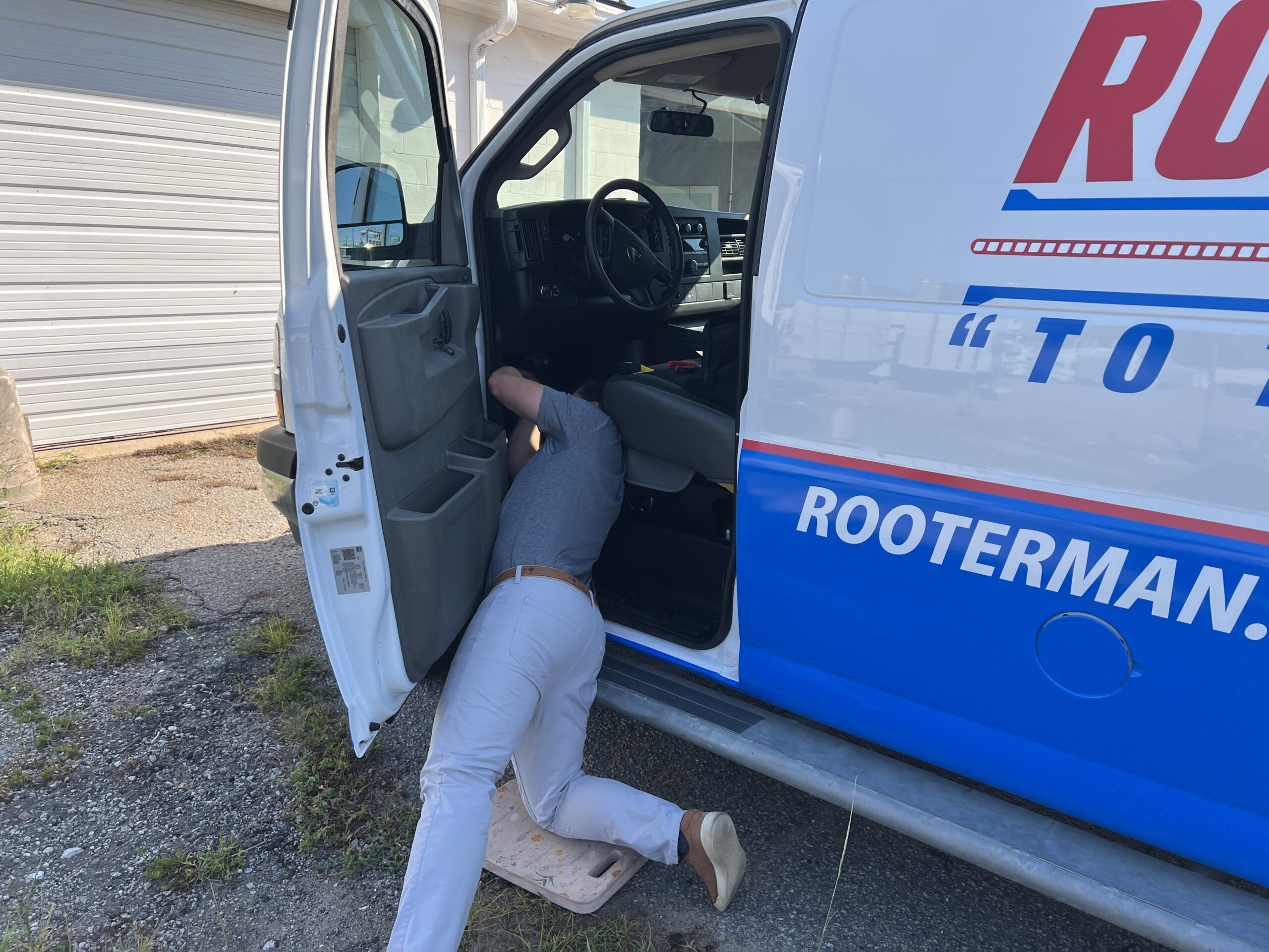 Ashley Cannon with Fuel Express installing a GPS tracker on Rooter Man Plumbing's newly wrapped Charleston service van