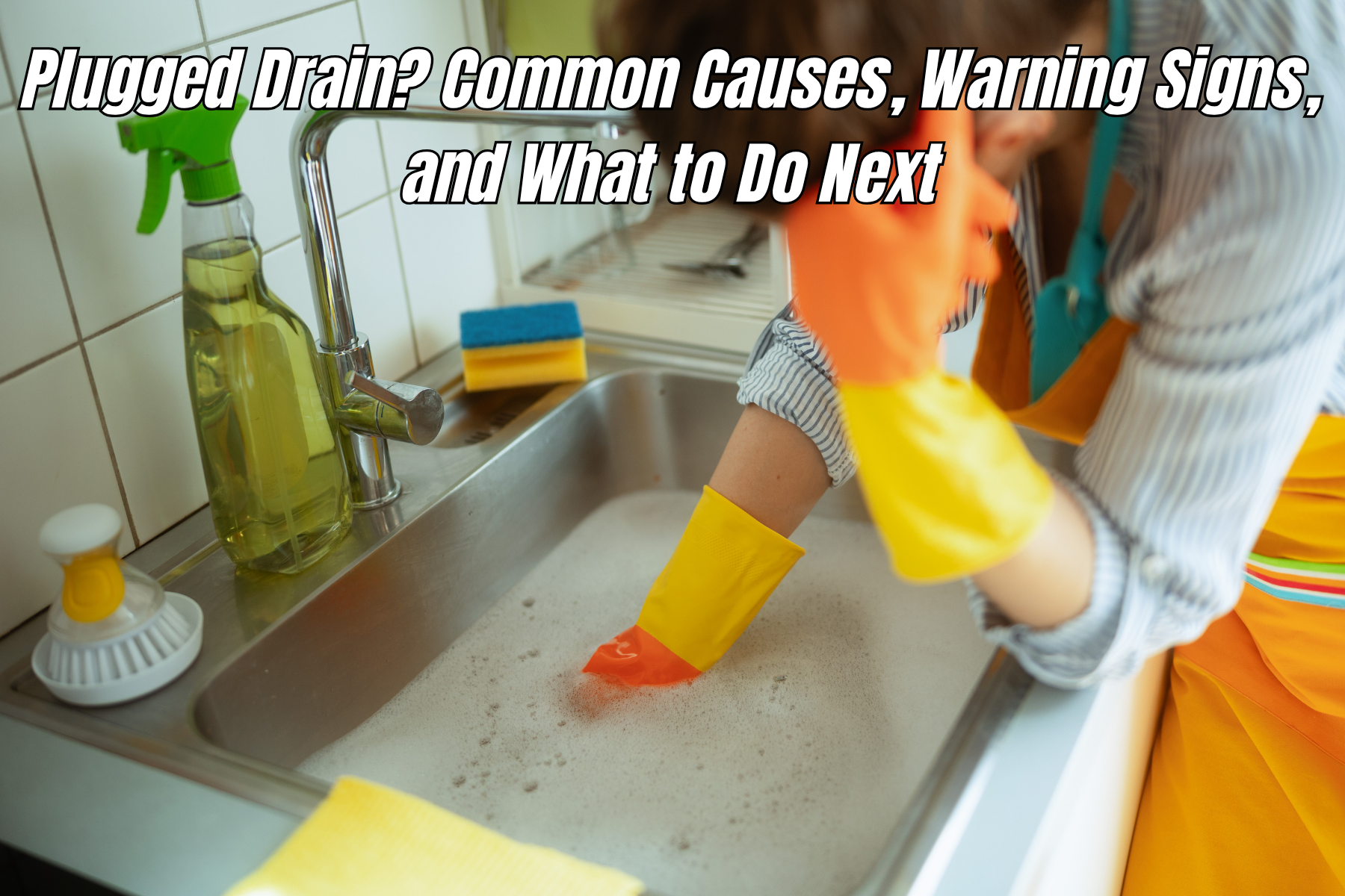 Person trying to clear a plugged kitchen sink drain